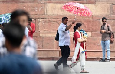YENİ DELHI, INDIA - 26 Nisan 2025 tarihinde, insanlar kendilerini sıcak öğleden sonra, Kızıl Kale 'de, Yeni Delhi, Hindistan' da, sert güneş ışığından korurken görülüyor.