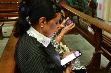 MUMBAI, INDIA - 26 Nisan 2025 'te Mumbai, Hindistan' da Papa Francis 'in fotoğrafının yanında oturan Hristiyan cemaati üyeleri, Papa' nın telefonundaki canlı yayını izliyorlar. Fotoğraf: Bhushan Koyande / Hindistan Saati