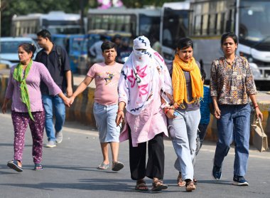 NOIDA, INDIA - 27 Nisan - Delhi-NCR 'de sıcaklık artarken, Hindistan' ın Noida şehrinde 27 Nisan 2025 'te 38A sektöründeki sıcaktan kaçmak için banliyö sakinleri başlarını örtüyor. En yüksek sıcaklık 41 derece civarındaydı ve en düşük sıcaklık da etraftaydı. 