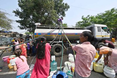 NEW DELHI, INDIA - 27 Nisan 2025 'te Hindistan' ın Yeni Delhi kentinde, Vivekanand Camp, Chanakyapuri 'de devam eden su krizinin ortasında, sıcak bir yaz gününde insanlar bir NDMC tankerinden su topluyor.. 