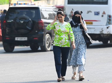 NOIDA, INDIA - 27 Nisan - Delhi-NCR 'de sıcaklık artarken, Hindistan' ın Noida şehrinde 27 Nisan 2025 'te 38A sektöründeki sıcaktan kaçmak için banliyö sakinleri başlarını örtüyor. En yüksek sıcaklık 41 derece civarındaydı ve en düşük sıcaklık da etraftaydı. 