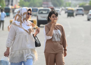 NOIDA, INDIA - 27 Nisan - Delhi-NCR 'de sıcaklık artarken, Hindistan' ın Noida şehrinde 27 Nisan 2025 'te 38A sektöründeki sıcaktan kaçmak için banliyö sakinleri başlarını örtüyor. En yüksek sıcaklık 41 derece civarındaydı ve en düşük sıcaklık da etraftaydı. 