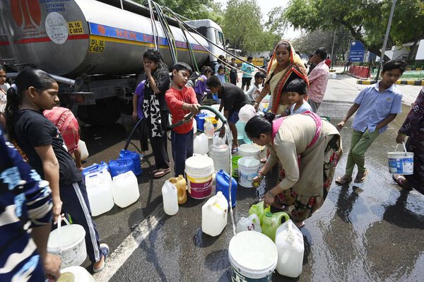НЬЮ-ДЕЛИ, Индия - 27 апреля: Люди собирают воду из танкера NDMC в жаркий летний день, когда водный кризис продолжается на фоне продолжающегося водного кризиса в лагере Вивекананд, Чанакьяпури, 27 апреля 2025 года в Нью-Дели, Индия. 