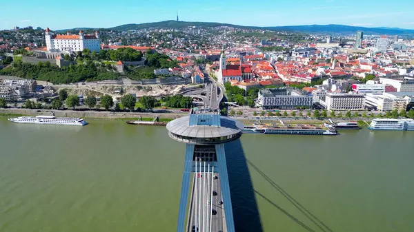 Çoğu SNP-UFO köprüsünün insansız hava aracı fotoğrafı. Bu tarihi köprü Tuna Nehri 'ni geçer ve şehrin panoramik manzarasını sunan fütüristik tasarımı ve UFO şekilli gözlem güvertesiyle dikkat çekicidir..
