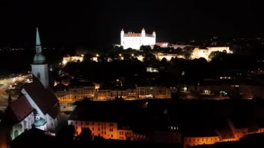 Bratislava 'nın tarihi St. Martin Katedrali' nden Bratislava Kalesi 'ne doğru uçan hava aracı gece videosu.