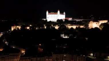 Slovakya 'nın tarihi Bratislava Kalesi' ne doğru uçan güzel bir hava aracı gecesi videosu..