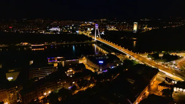Bratislava, Slovakya 'nın tarihi SNP-UFO Köprüsü ve Tuna Nehri' nin insansız hava aracı gece fotoğrafı.