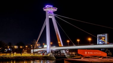Çoğu SNP 'nin gece fotoğrafı. Çoğu SNP, aynı zamanda UFO Köprüsü olarak da bilinir, Slovakya 'nın Bratislava şehrinde ikonik bir yapıdır. Bu çarpıcı köprü Tuna Nehri boyunca uzanır ve şehrin panoramik manzarasını sunan UFO şekilli gözlem güvertesiyle dikkat çekicidir..