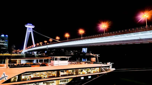 stock image Night photo of Most SNP. Most SNP, also known as the UFO Bridge, is an iconic structure in Bratislava, Slovakia. This striking bridge spans the Danube River and is notable for its UFO-shaped observation deck, offering panoramic views of the city.