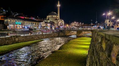 Prizren, Kosova ve Bistrica Nehri 'nin Gece Fotoğrafı. Nehir şehirde akıyor, cazibesini arttırıyor ve rahatlama ve rahatlama faaliyetleri için pitoresk yerler sağlıyor.