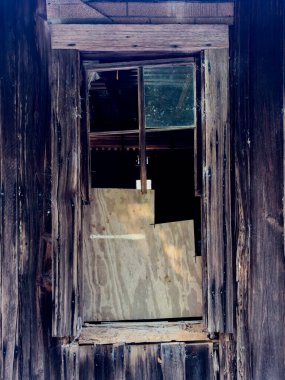 Eski ıssız bir kır evinde harap olmuş bir pencere.