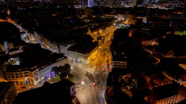 Bratislava Eski Kasabası, Slovakya 'nın hava aracı gece fotoğrafı. Sokakta dolaşan bir tramvayı gösteriyor..