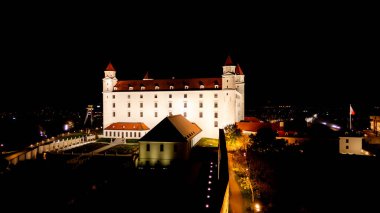 Bratislava, Slovakya 'daki Bratislava Kalesi' nin hava aracı gece fotoğrafı. Bratislava Kalesi, Slovakya 'nın başkenti Bratislava ve Tuna Nehri' nin üzerinde yer almaktadır. Şatoyu ziyaret ederken, şehrin muhteşem manzarasının tadını çıkarabilirsiniz..