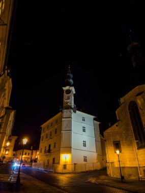 Banska Stiavnica 'daki belediye binasının gece fotoğrafı. Tarihi bir 15. yüzyıl binasıdır ve şehir UNESCO Dünya Mirası Alanı olarak tanınmaktadır..