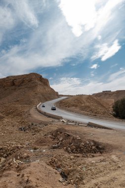 Suudi Arabistan, Riyad 'daki Wadi Hanifa yakınlarındaki manzara ve yol. Vadi Hanifa, Suudi Arabistan 'ın Riyad kentinden kuzeybatıdan güneydoğuya yaklaşık 120 kilometre uzanan önemli bir doğal vadidir..