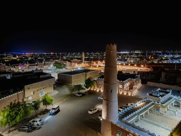 Shaqra 'nın hava gece drone görüntüsü aydınlatılmış şehir manzaraları, tarihi Najdi mimarisi ve önemli kültürel simgeler.