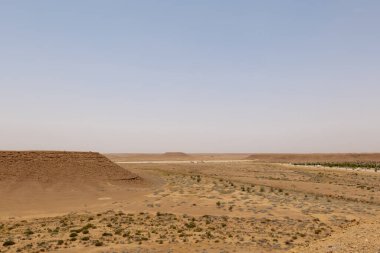 Suudi Arabistan 'ın El-Majma kenti yakınlarında çekilen bir çöl fotoğrafı Orta Arap manzarasının dingin güzelliğini yansıtıyor. Gökyüzü engin ve berrak, çölün genişliğini vurguluyor..