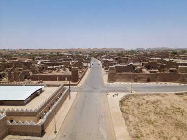 Aerial drone image of Shaqra Heritage Village showcasing preserved Najdi mudbrick homes, winding alleyways, and fortified walls, capturing the essence of Saudi heritage.