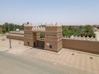 Aerial drone image of Shaqra Heritage Village showcasing preserved Najdi mudbrick homes, winding alleyways, and fortified walls, capturing the essence of Saudi heritage.