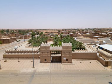 Aerial drone image of Shaqra Heritage Village showcasing preserved Najdi mudbrick homes, winding alleyways, and fortified walls, capturing the essence of Saudi heritage.