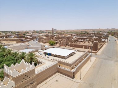 Aerial drone image of Shaqra Heritage Village showcasing preserved Najdi mudbrick homes, winding alleyways, and fortified walls, capturing the essence of Saudi heritage.