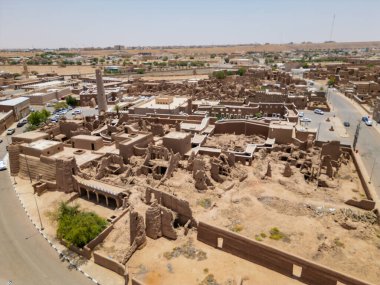 Aerial drone image of Shaqra Heritage Village showcasing preserved Najdi mudbrick homes, winding alleyways, and fortified walls, capturing the essence of Saudi heritage.