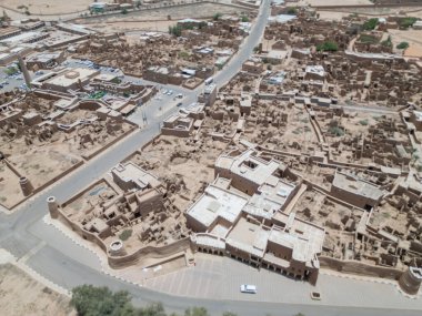 Aerial drone image of Shaqra Heritage Village showcasing preserved Najdi mudbrick homes, winding alleyways, and fortified walls, capturing the essence of Saudi heritage.