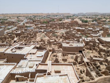 Aerial drone image of Shaqra Heritage Village showcasing preserved Najdi mudbrick homes, winding alleyways, and fortified walls, capturing the essence of Saudi heritage.