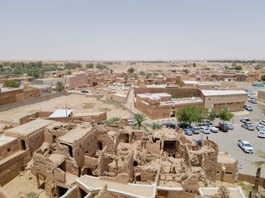Aerial drone image of Shaqra Heritage Village showcasing preserved Najdi mudbrick homes, winding alleyways, and fortified walls, capturing the essence of Saudi heritage.