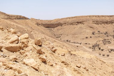 Suudi Arabistan 'ın Riyad yakınlarındaki çöl manzarası geniş ve açık arazi ve kaya oluşumlarını gösteriyor. Bu resim doğal manzaranın sessiz güzelliğini yakalar..