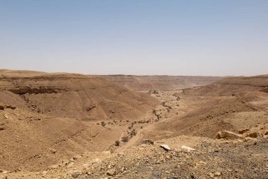 Suudi Arabistan 'ın Riyad yakınlarındaki çöl manzarası geniş ve açık arazi ve kaya oluşumlarını gösteriyor. Bu resim doğal manzaranın sessiz güzelliğini yakalar..