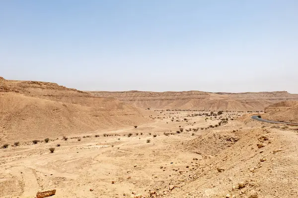 Suudi Arabistan 'ın Riyad yakınlarındaki çöl manzarası geniş ve açık arazi ve kaya oluşumlarını gösteriyor. Bu resim doğal manzaranın sessiz güzelliğini yakalar..