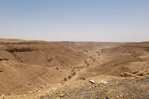 Suudi Arabistan 'ın Riyad yakınlarındaki çöl manzarası geniş ve açık arazi ve kaya oluşumlarını gösteriyor. Bu resim doğal manzaranın sessiz güzelliğini yakalar..