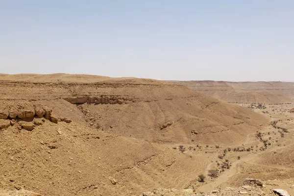 Suudi Arabistan 'ın Riyad yakınlarındaki çöl manzarası geniş ve açık arazi ve kaya oluşumlarını gösteriyor. Bu resim doğal manzaranın sessiz güzelliğini yakalar..