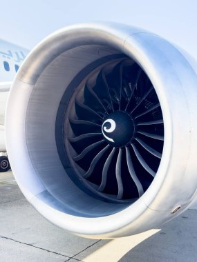 Bir yolcu uçağının kanadının altına monte edilmiş ticari bir jet motorunun detaylı yakın çekimi. Görüntü, modern havacılık teknolojisinin hassas mühendislik ve aerodinamik tasarımını vurguluyor.. 
