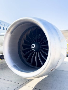 Bir yolcu uçağının kanadının altına monte edilmiş ticari bir jet motorunun detaylı yakın çekimi. Görüntü, modern havacılık teknolojisinin hassas mühendislik ve aerodinamik tasarımını vurguluyor.. 