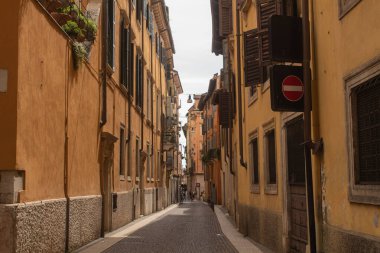 İtalya 'nın Verona, Veneto bölgesindeki antik caddesindeki parlak mavi gökyüzü arka planına sahip binaların yatay genel plan fotoğrafı. Veronese Yazın güzel sokaklar