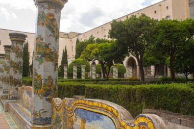 Güzel fayanslı sütunlar ve İtalya, Napoli 'deki Santa Chiara Manastırı' nın manastır bahçesinde bulunan mayolik süslerle süslü bank. İtalya 'da Tatil
