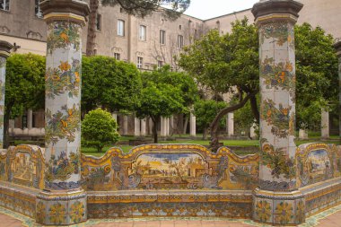 Güzel fayanslı sütunlar ve İtalya, Napoli 'deki Santa Chiara Manastırı' nın manastır bahçesinde bulunan mayolik süslerle süslü bank. İtalya 'da Tatil