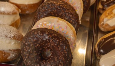 Taze yağlı çikolata ve kafede üzerine krema serpiştirilmiş vanilyalı çörek. Bir fırında kahve molası, kapuçino ve şekerle..