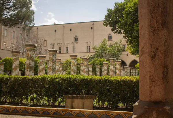 stock image Pathway through a park with fountain and beautiful tiled pillars plated at the cloister garden of Santa Chiara Monastery, Naples, Italy. Vacation in Italy