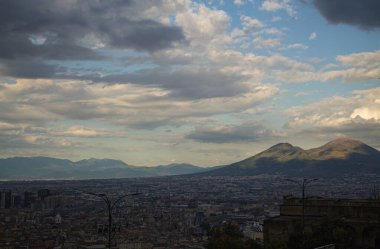 Napoli ve Napoli Körfezi 'nin güneyinde panoramik manzaralı bir şehir. Gün batımında pembe, sarı ve mavi bulutlar. Şehir manzarası ve gökyüzü Castel Sant 'Elmo, Napoli' den.