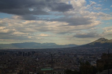 Napoli ve Napoli Körfezi 'nin güneyinde panoramik manzaralı bir şehir. Gün batımında pembe, sarı ve mavi bulutlar. Şehir manzarası ve gökyüzü Castel Sant 'Elmo, Napoli' den.