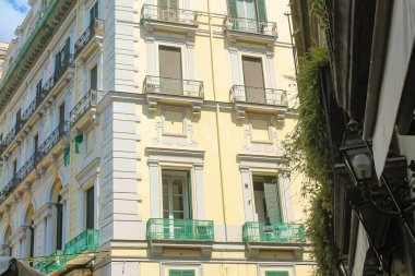 İtalya 'nın güneyindeki Napoli şehrinde balkonları olan parlak turuncu ve sarı binalar.
