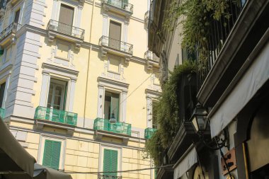 İtalya 'nın güneyindeki Napoli şehrinde balkonları olan parlak turuncu ve sarı binalar.