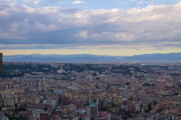 Napoli ve Napoli Körfezi 'nin güneyinde panoramik manzaralı bir şehir. Gün batımında pembe, sarı ve mavi bulutlar. Şehir manzarası ve gökyüzü Castel Sant 'Elmo, Napoli' den.