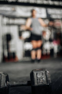 Spor salonunda dambılı bir kadın.