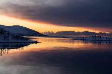  landscape sunset in snowy nature and sea in tromso clipart