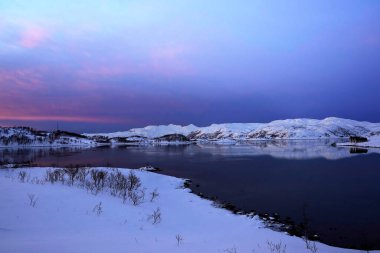  Tromso 'da karlı doğa ve deniz manzaralı gün batımı