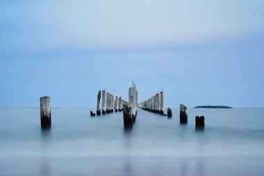 Uzun pozlu deniz ve ahşap sütunlar